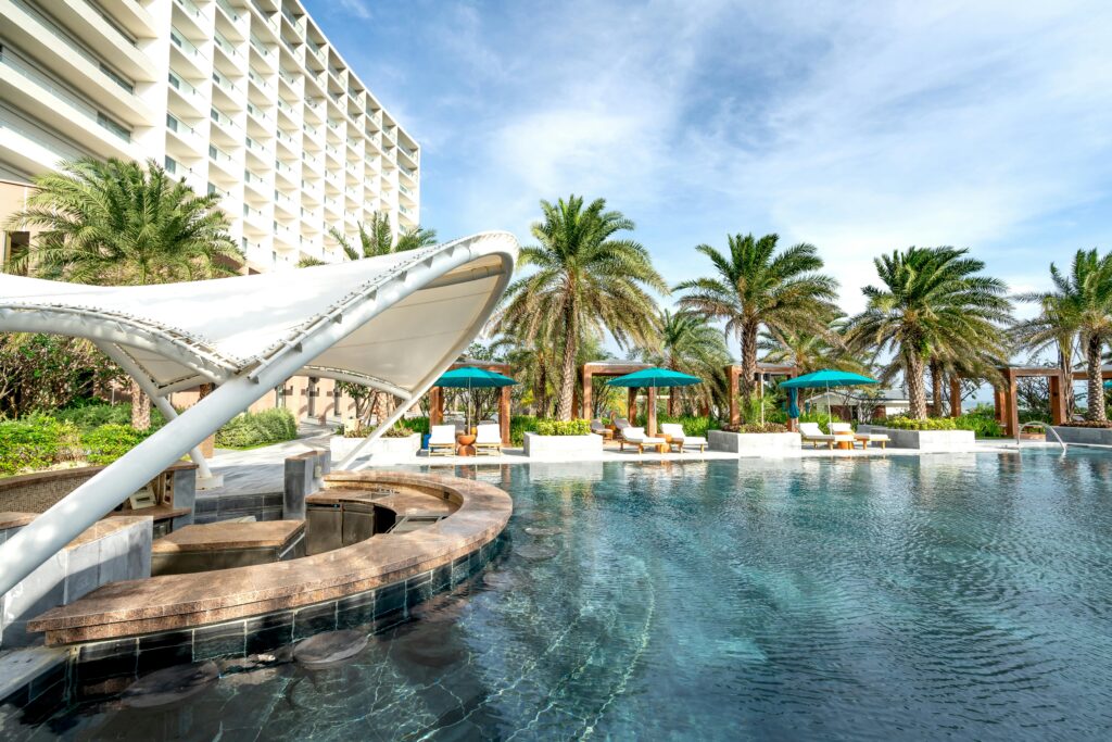 Explore this serene resort poolside, surrounded by lush palm trees and luxury amenities.